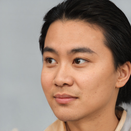 Joyful asian young-adult male with medium  black hair and brown eyes