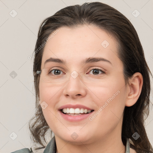 Joyful white young-adult female with medium  brown hair and grey eyes