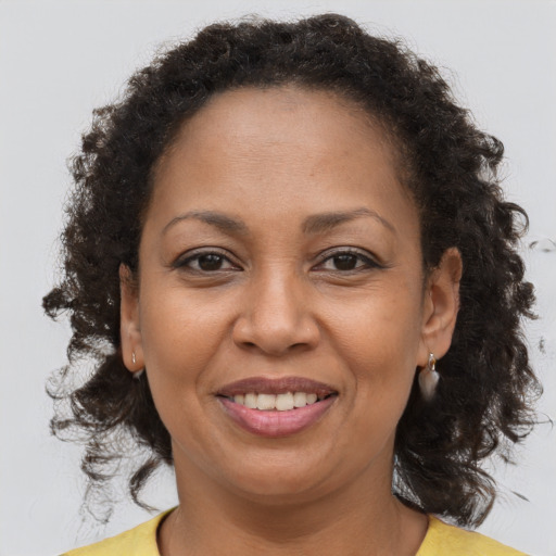 Joyful black adult female with long  brown hair and brown eyes