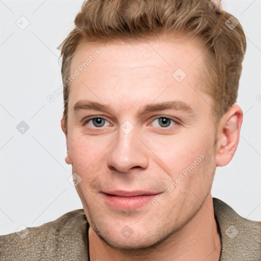 Joyful white young-adult male with short  brown hair and grey eyes