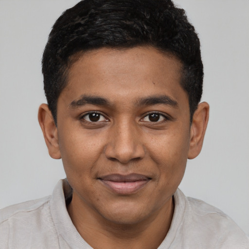 Joyful black young-adult male with short  black hair and brown eyes