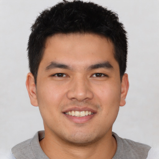 Joyful asian young-adult male with short  brown hair and brown eyes