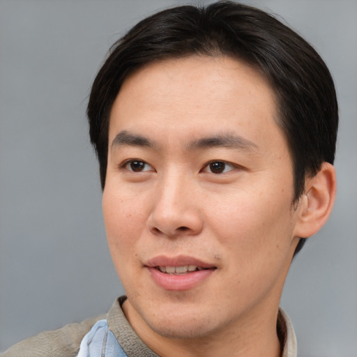 Joyful asian young-adult male with short  brown hair and brown eyes