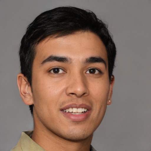 Joyful latino young-adult male with short  brown hair and brown eyes