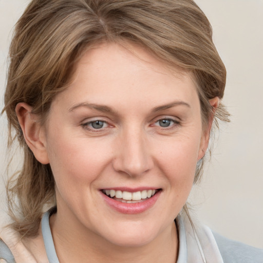 Joyful white young-adult female with medium  brown hair and blue eyes