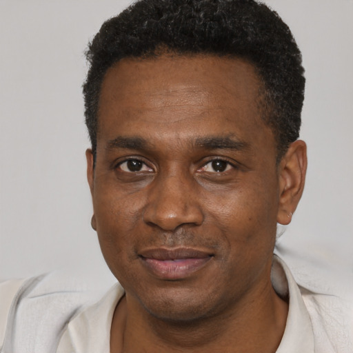 Joyful black young-adult male with short  black hair and brown eyes