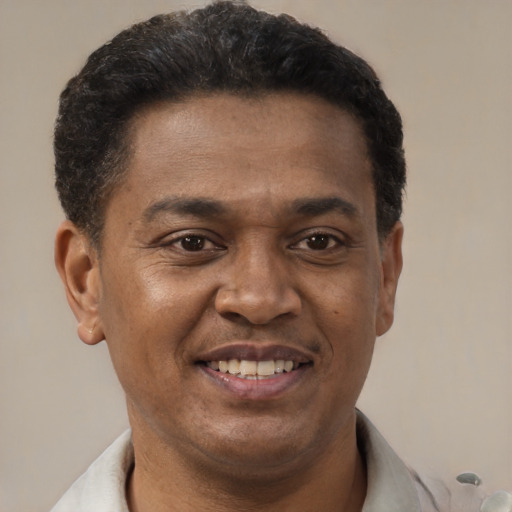 Joyful black adult male with short  brown hair and brown eyes