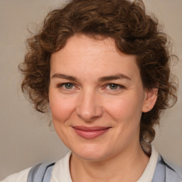 Joyful white adult female with medium  brown hair and blue eyes