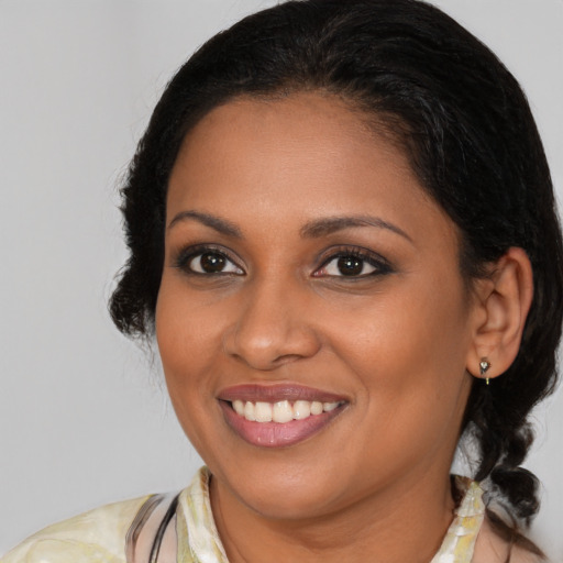 Joyful black young-adult female with medium  brown hair and brown eyes