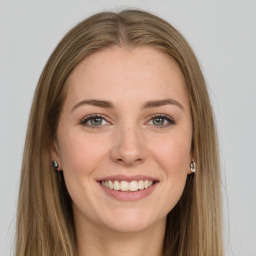 Joyful white young-adult female with long  brown hair and green eyes