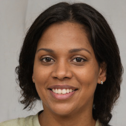 Joyful black young-adult female with medium  brown hair and brown eyes