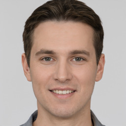 Joyful white young-adult male with short  brown hair and grey eyes