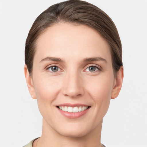 Joyful white young-adult female with short  brown hair and grey eyes