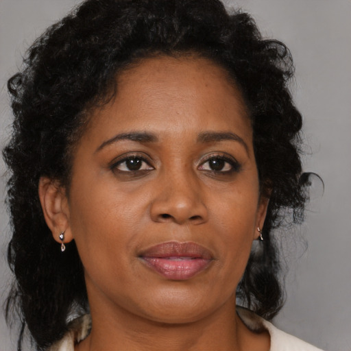 Joyful black adult female with medium  brown hair and brown eyes