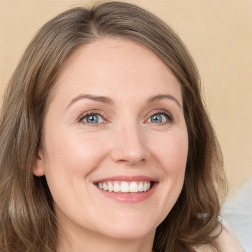 Joyful white young-adult female with long  brown hair and green eyes