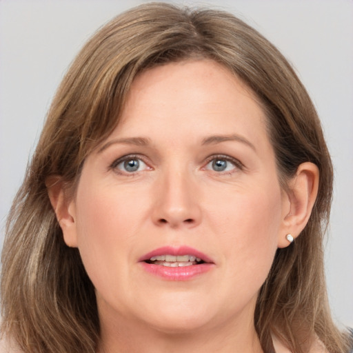 Joyful white adult female with medium  brown hair and grey eyes