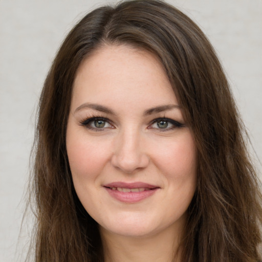 Joyful white young-adult female with long  brown hair and green eyes