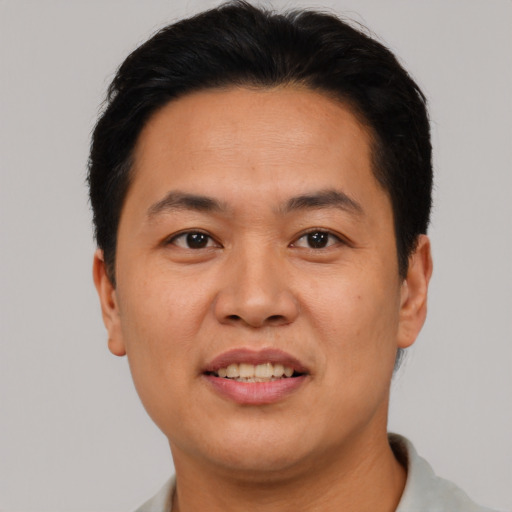 Joyful asian adult male with short  black hair and brown eyes