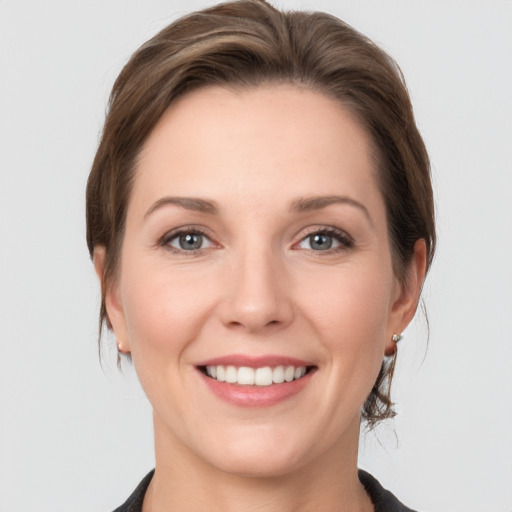 Joyful white young-adult female with medium  brown hair and grey eyes