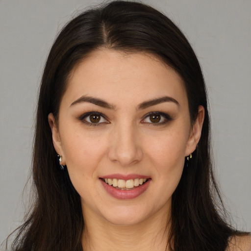 Joyful white young-adult female with long  brown hair and brown eyes