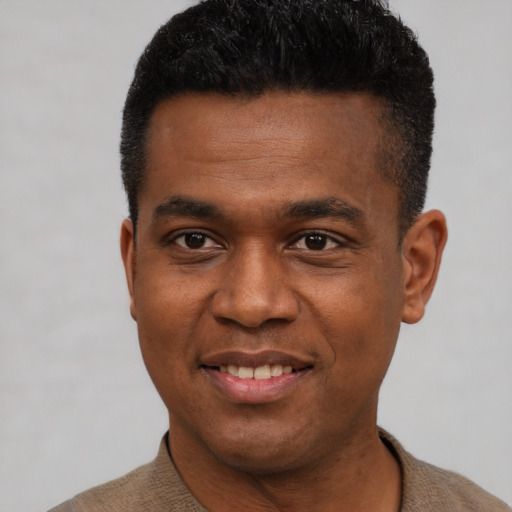 Joyful black young-adult male with short  black hair and brown eyes