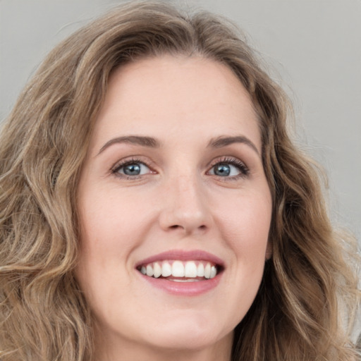 Joyful white young-adult female with long  brown hair and green eyes