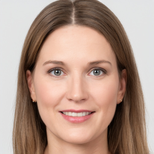 Joyful white young-adult female with long  brown hair and grey eyes