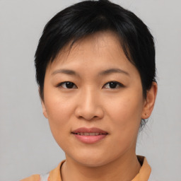 Joyful asian young-adult female with short  brown hair and brown eyes