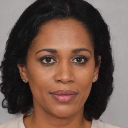 Joyful black young-adult female with medium  brown hair and brown eyes