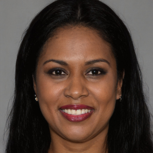 Joyful black young-adult female with long  brown hair and brown eyes