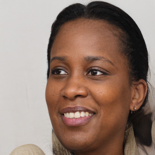 Joyful black young-adult female with long  brown hair and brown eyes