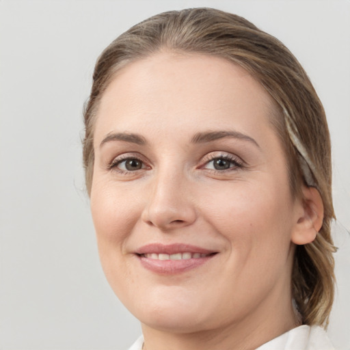 Joyful white young-adult female with medium  brown hair and grey eyes