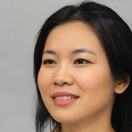 Joyful asian young-adult female with long  black hair and brown eyes