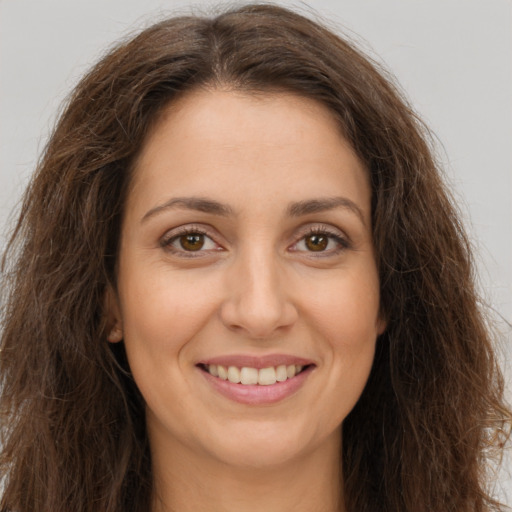 Joyful white young-adult female with long  brown hair and brown eyes