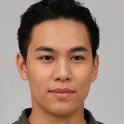 Joyful asian young-adult male with short  brown hair and brown eyes