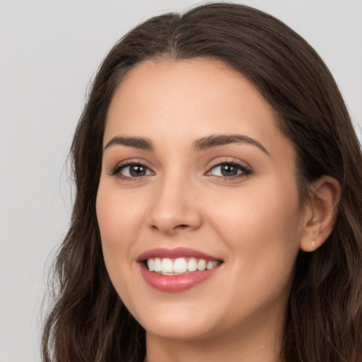 Joyful white young-adult female with long  brown hair and brown eyes