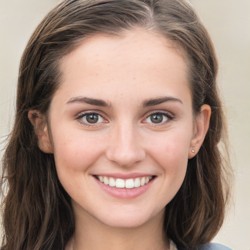 Joyful white young-adult female with long  brown hair and grey eyes