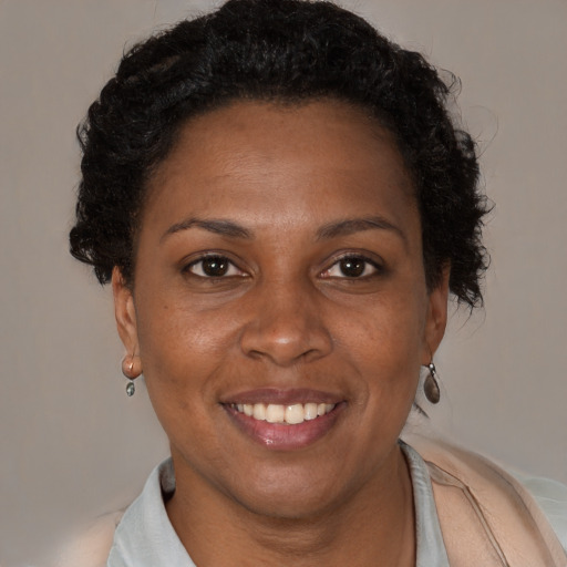 Joyful black adult female with short  brown hair and brown eyes
