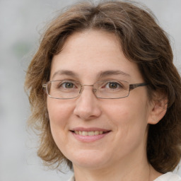 Joyful white adult female with medium  brown hair and grey eyes