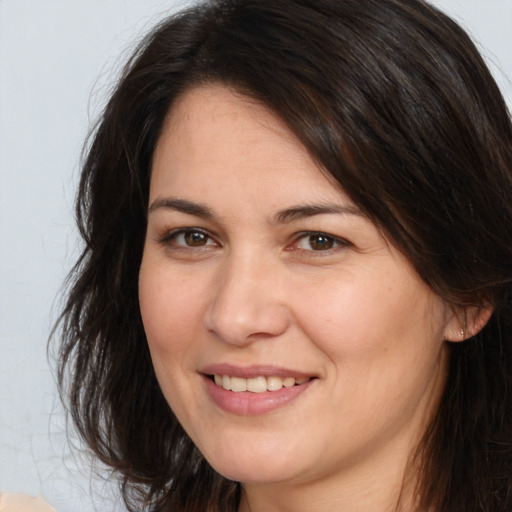 Joyful white young-adult female with long  brown hair and brown eyes