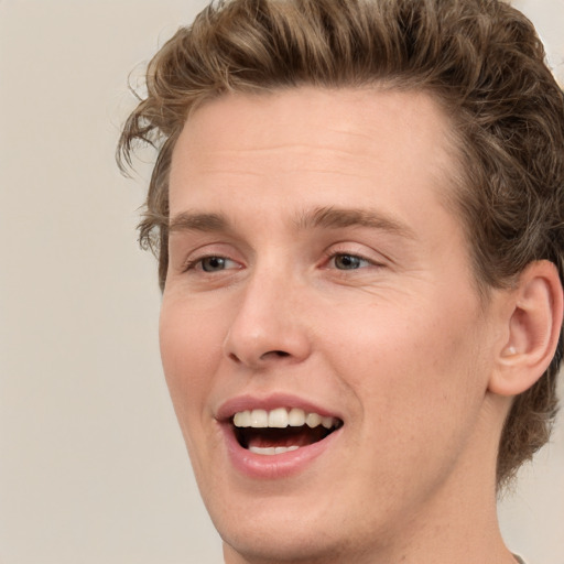 Joyful white young-adult male with short  brown hair and green eyes