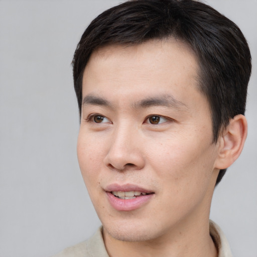 Joyful asian young-adult male with short  brown hair and brown eyes