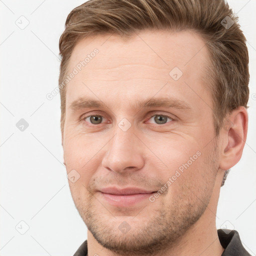 Joyful white young-adult male with short  brown hair and grey eyes