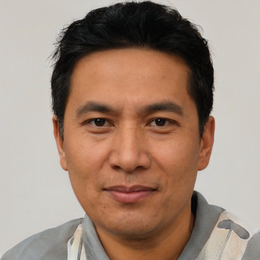 Joyful asian adult male with short  black hair and brown eyes