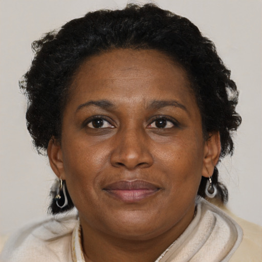 Joyful black adult female with short  brown hair and brown eyes