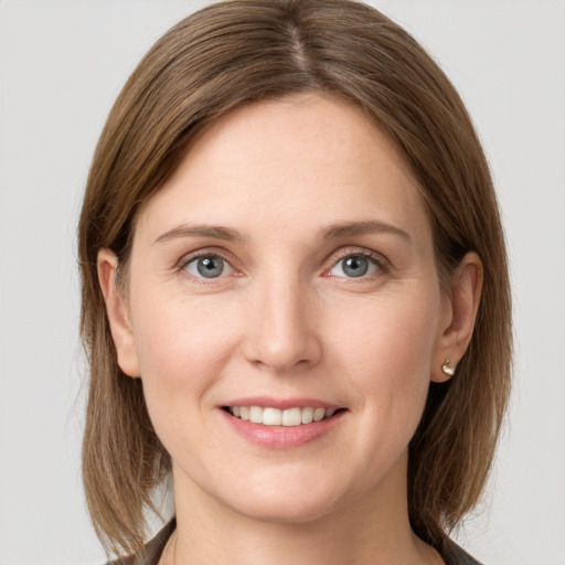 Joyful white young-adult female with medium  brown hair and grey eyes