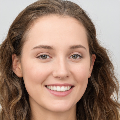 Joyful white young-adult female with long  brown hair and blue eyes