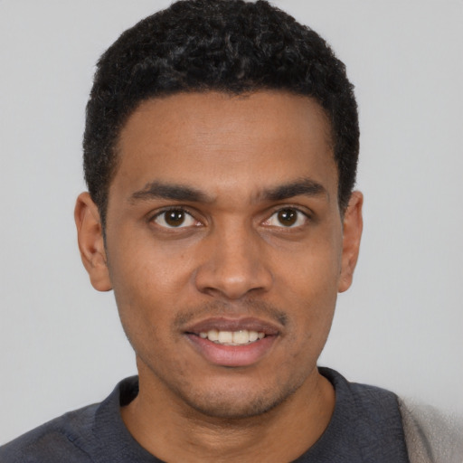 Joyful black young-adult male with short  black hair and brown eyes