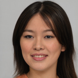 Joyful asian young-adult female with long  brown hair and brown eyes