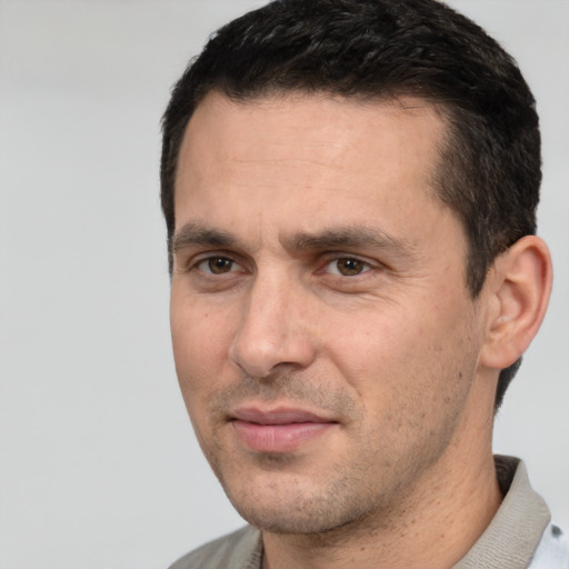 Joyful white adult male with short  black hair and brown eyes